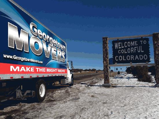 Georgetown Moving & Storage truck next to "Welcome to Colorful Colorado" sign.