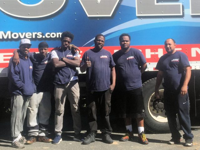 Georgetown Moving and Storage movers standing together in front of a service truck.