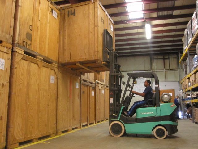 Georgetown employee moving storage containers with forklift