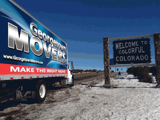 Georgetown Moving van driving past a road sign that says "Welcome to Colorful Colorado."