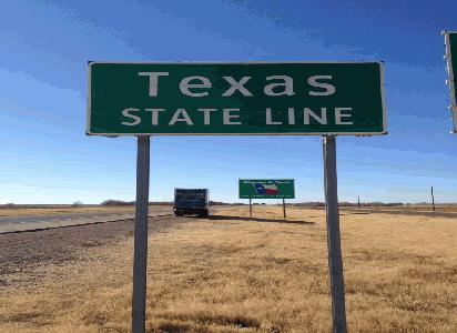  Road sign that says "Texas State Line"