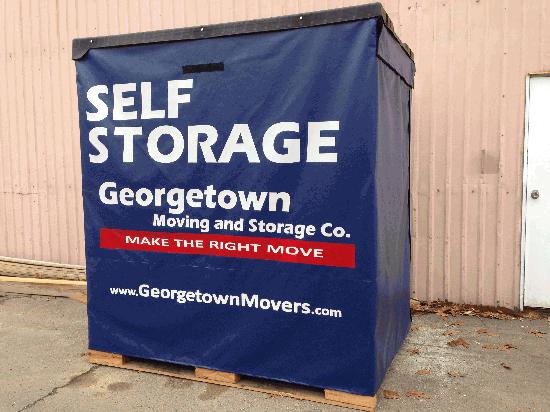 Large blue storage container from Georgetown Moving and Storage, sitting outside on a pallet.
